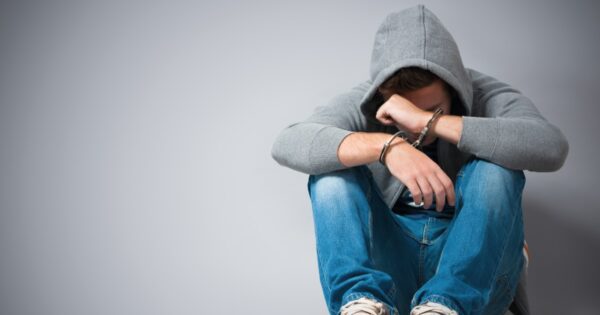 chaval con sudadera sentado y cabizbajo
